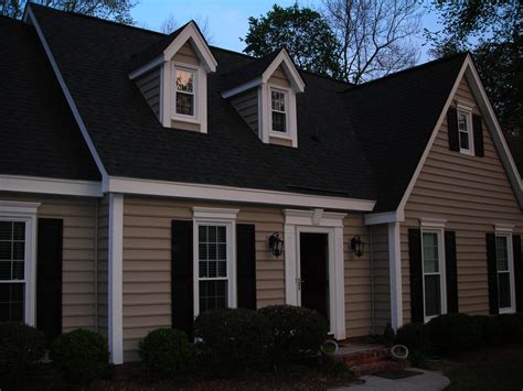 brown house with black metal roof|brown house with black shutters.